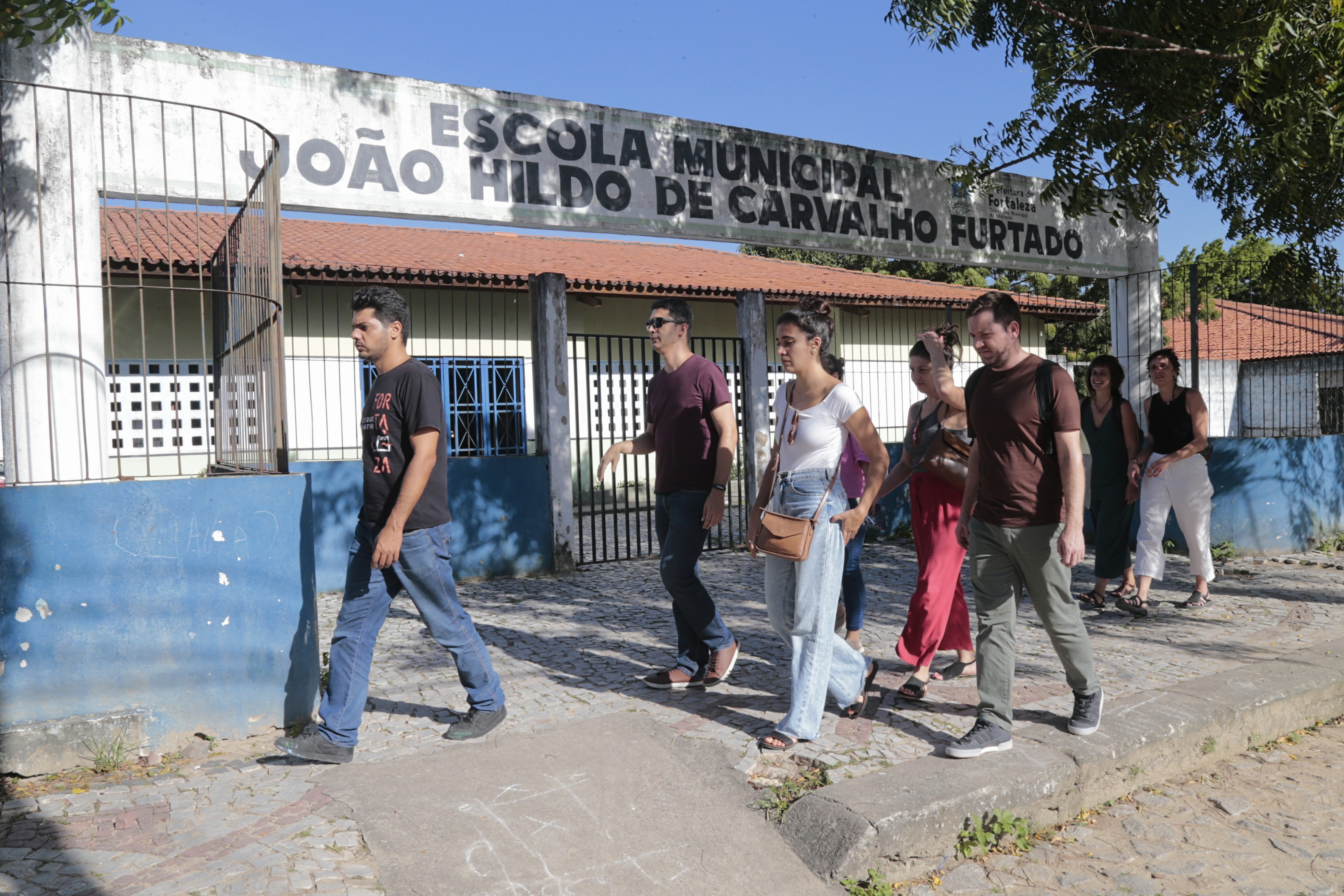 grupo caminha em frente a um centro de educação infantil